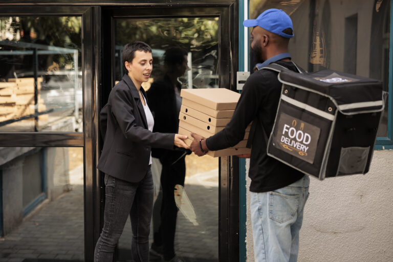 Food delivery service courier giving customer pizza order.