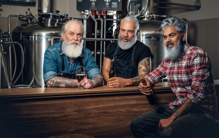 Three elderly brewery drinking beer in modern beer factory