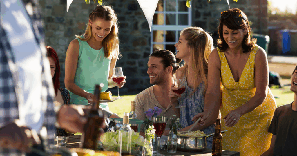 Friends Enjoying Outdoor Summer BBQ with Wine and Food