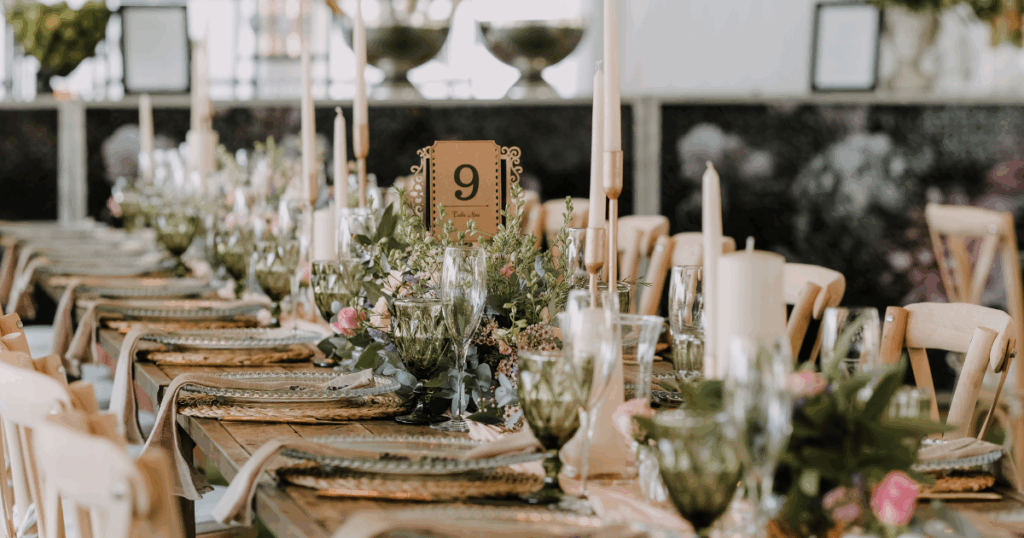 Formal event table setting with wine glasses and menus prepared for guests at a bulk liquor-supported party or corporate event.