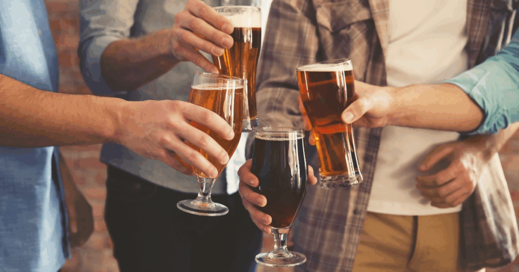 Group of friends clinking glasses of craft beer, celebrating new beer trends for 2025