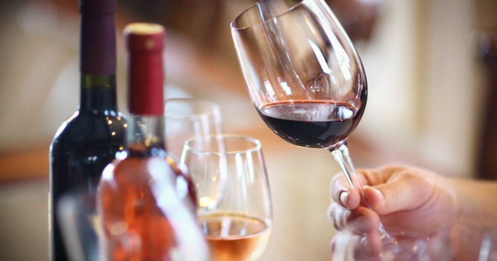 Friends clinking glasses of red and white wine with cheese board – perfect wine pairing for any occasion