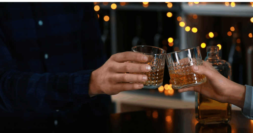 Two people clinking glasses of bourbon during a holiday celebration in Kansas City, highlighting allocated whiskey from Pina’s Inner Circle.