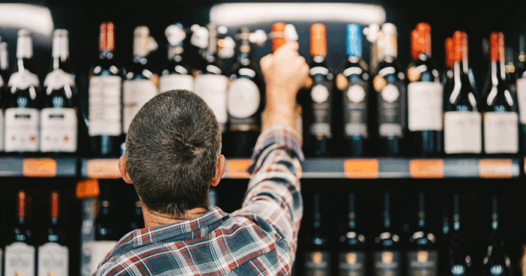 Customer browsing wine shelves at a Kansas City liquor store featuring a wide wine selection at Pina Wine and Spirits.
