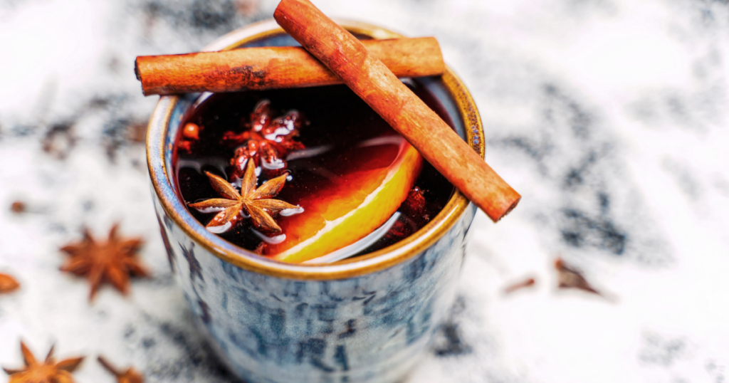 Warm mulled wine topped with cinnamon sticks and star anise, showcasing a cozy winter cocktail made with seasonal spirits.