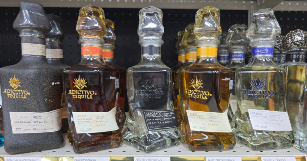 Where to Find the Best Liquor Deals in and around Kansas City: Pina Wine & Spirits Store Guide 1 Adictivo tequila bottles on a store shelf at Pina Wine and Spirits, showing Blanco Craft, Añejo, Reposado Cristalino, Reposado, and Plata with the best liquor deals and pricing for Kansas City liquor deals.