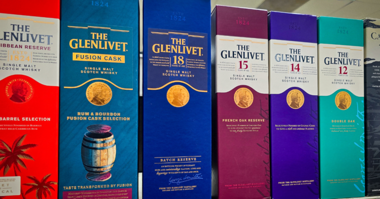 The Glenlivet single malt Scotch whisky lineup on a shelf with the best prices at Pina Wine and Spirits in Kansas City, featuring Caribbean Reserve, Fusion Cask, 18 Year, 15 Year, 14 Year, and 12 Year options.
