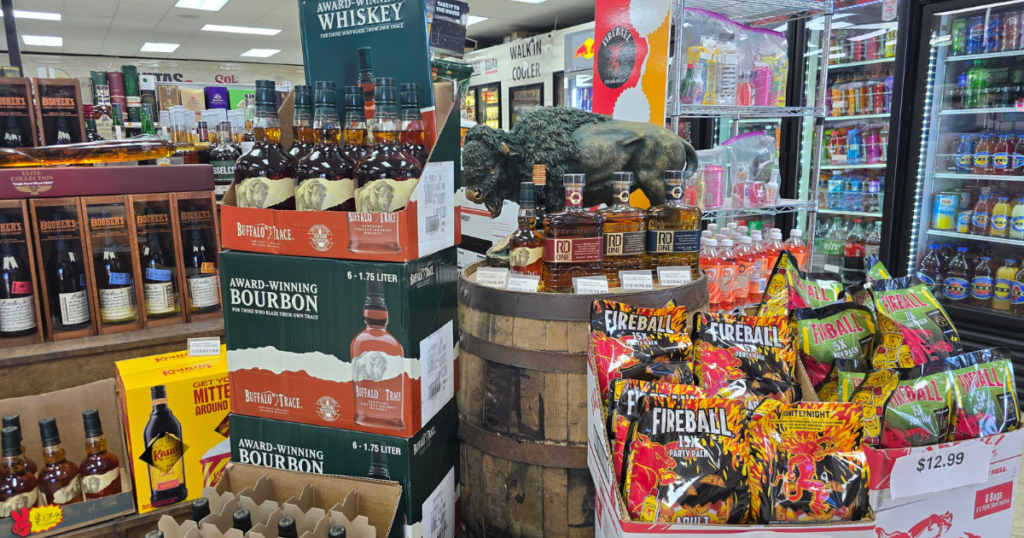 In-store whiskey and bourbon display with the best prices at Pina Wine and Spirits in Kansas City with Buffalo Trace case stack, RD One bourbon bottles on a barrel, and featured value buys for spirits shoppers.